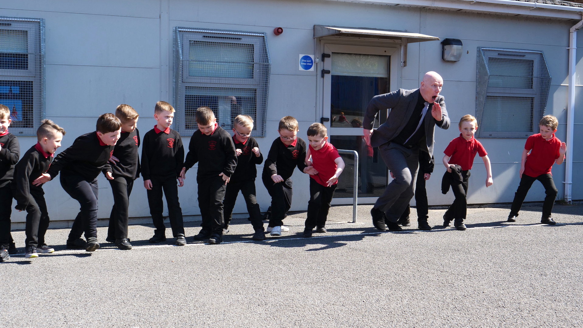 muž a skupina malých chlapců se rozebíhá